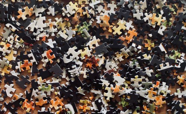 Black, Grey, And Orange Puzzle Pieces To Represent Part Of The Investing Puzzle By Apprise Wealth Management