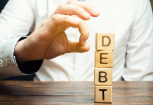 Businessman Removes Wooden Blocks With The Word Debt