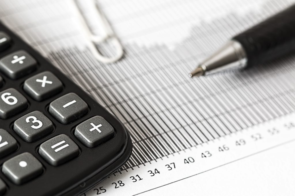 A Calculator With Pen And Chart - Tax Planning Tips for the Year-End and New Years