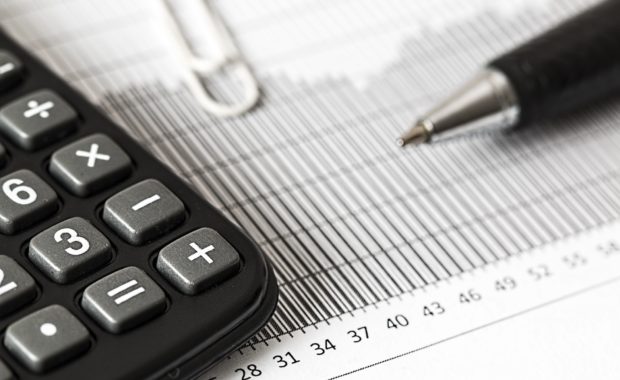 A Calculator With Pen And Chart - Tax Planning Tips for the Year-End and New Years