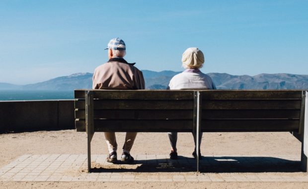 A Retired Couple Sitting On A Park Bench