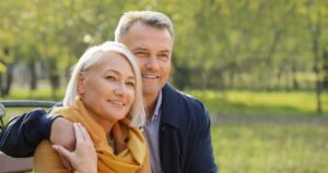 A Retired Cople Sitting On A Park Bench Enjoying Retirement