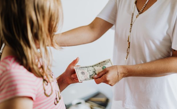 Mother Giving Child Money To Teach Them Personal Finance