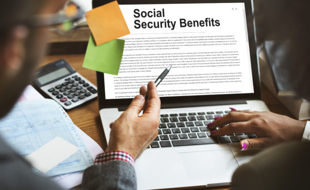 Financial Advisors On A Laptop Reviewing Social Security Benefits Agreement