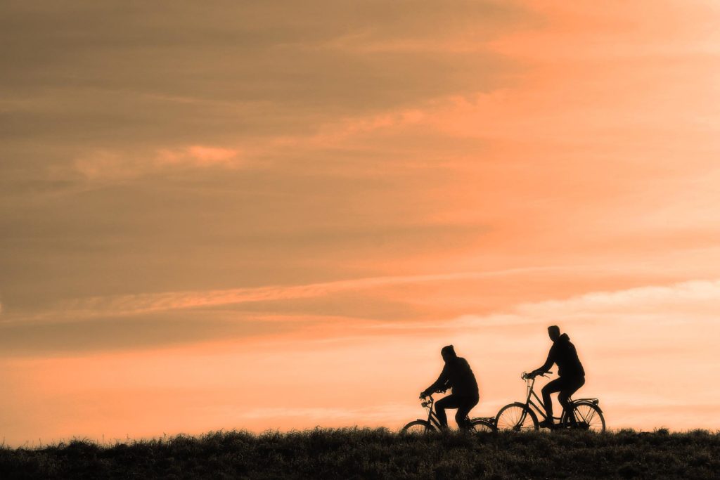 Two People Cycling During Sunset and How to Keep Your Brain Healthy and Happy