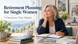 A woman in retirement planning mode sits at a table with a notebook, travel materials, and a scenic view, representing retirement planning for single women.